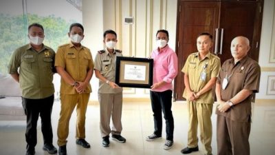 PRESTASI Bupati Sam Sachrul Mamonto saat menerima piagam penghargaan dari Kepala BPN Boltim Yandri Rori.