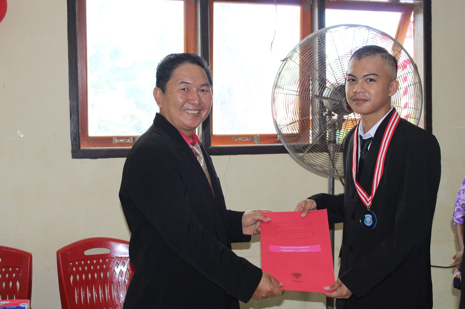 APRESIASI: Kepsek Sonny Seon saat memberikan selamat pada siswa.