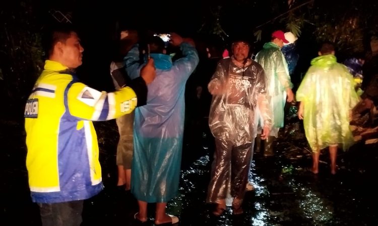 Personil Polsek Tikala saat membersihkan pohon tumbang di jalan Pinkan Matindas, Dendengan Dalam, Kota Manado.